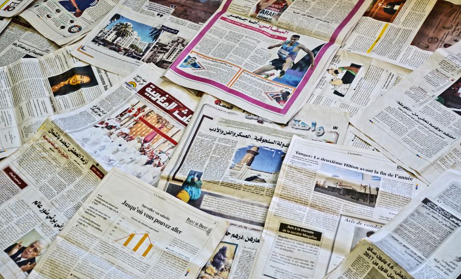 Close-up view of various newspapers laid out, showcasing diverse headlines and articles.
